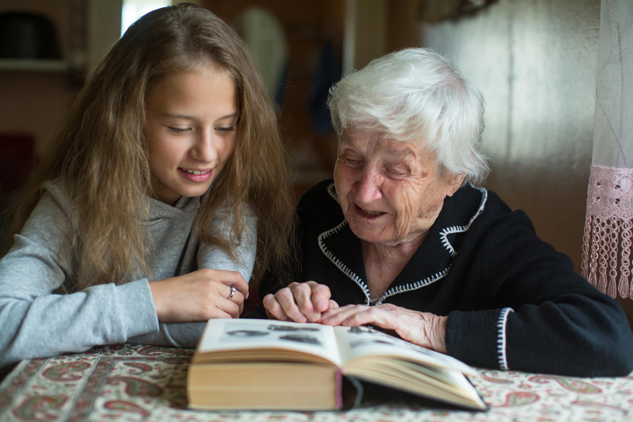 Grandmother and granddaughter sharing memories from a photo album
